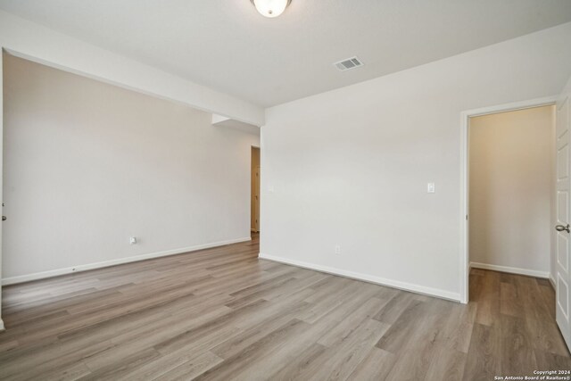 empty room with light hardwood / wood-style flooring