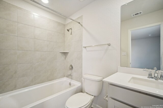 full bathroom with toilet, vanity, and tiled shower / bath