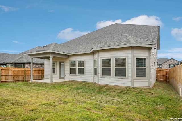 rear view of property featuring a yard and a patio area