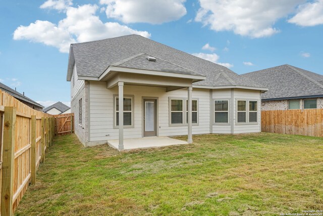 rear view of property with a yard and a patio area