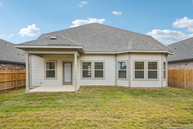 rear view of property featuring a lawn and a patio area