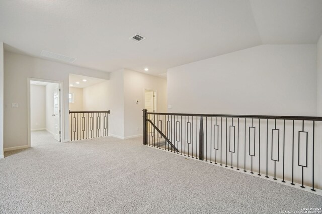 unfurnished room with lofted ceiling and light colored carpet