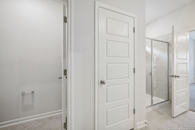 bathroom featuring an enclosed shower and tile patterned flooring