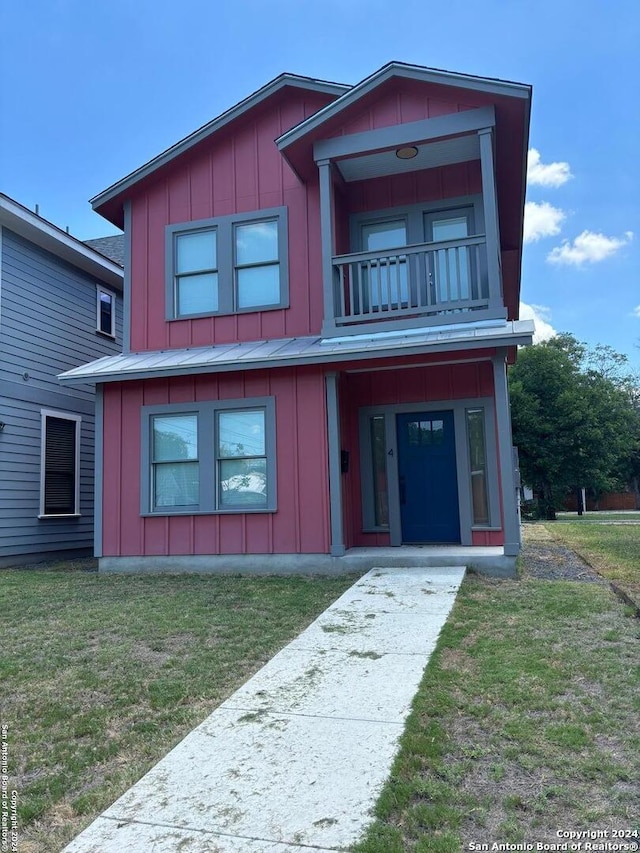 view of front of property featuring a balcony and a front lawn