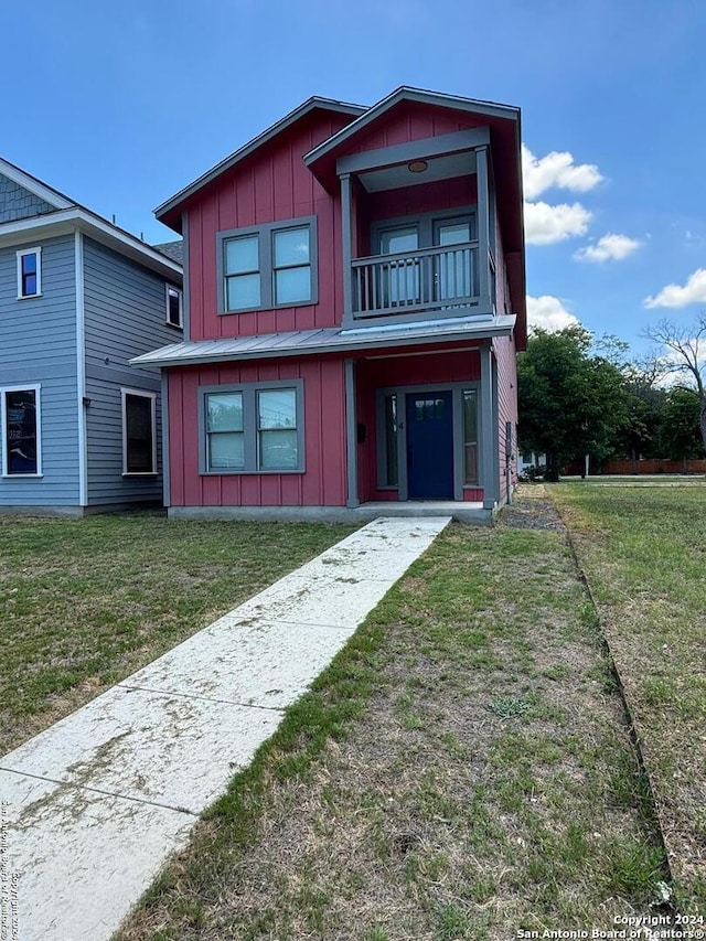 view of front of home with a balcony and a front lawn