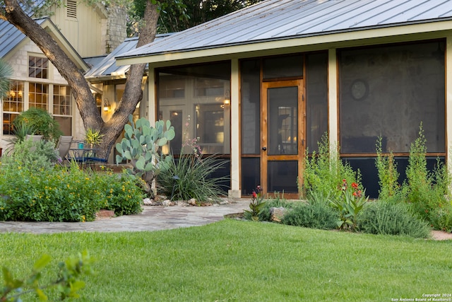 view of exterior entry featuring a yard