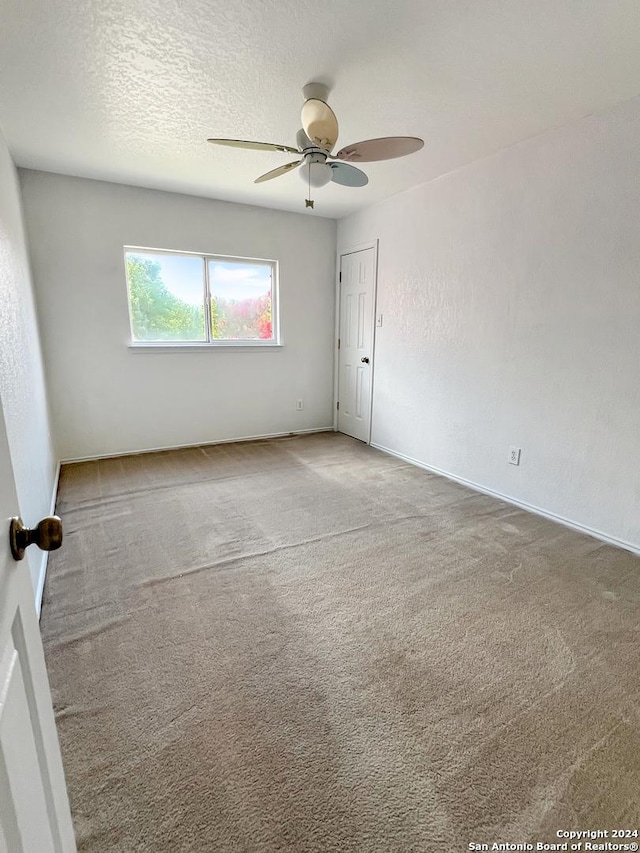 empty room with carpet, a textured ceiling, and ceiling fan