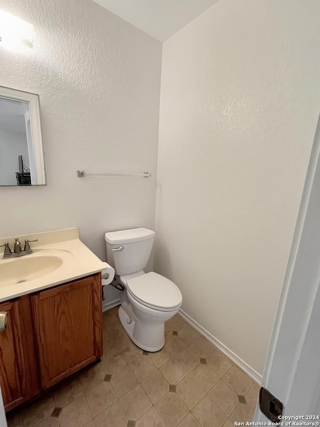 bathroom with tile patterned flooring, vanity, and toilet