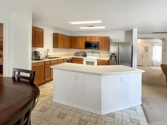 kitchen featuring sink, a center island, stainless steel appliances, and a textured ceiling