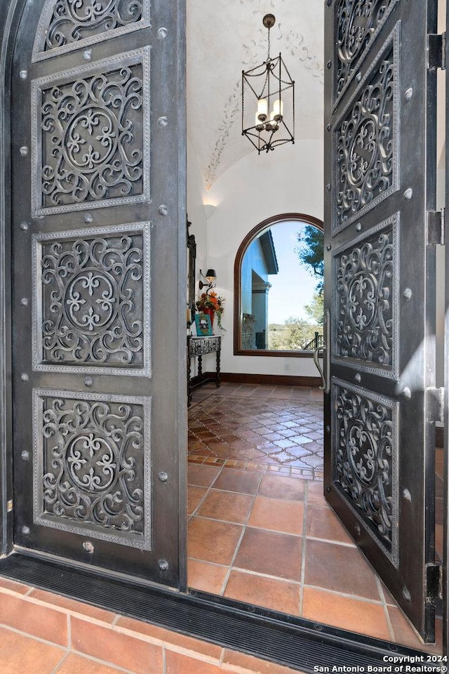 foyer featuring an inviting chandelier and vaulted ceiling