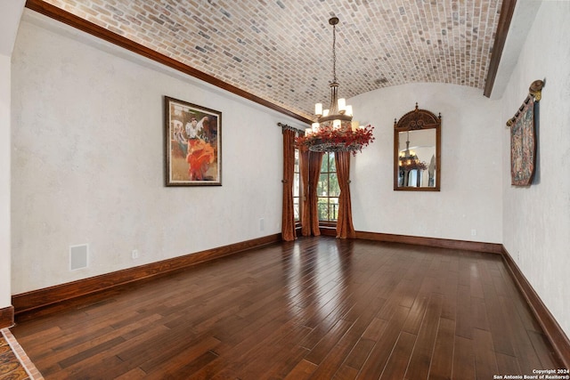 unfurnished dining area with dark wood-type flooring, a notable chandelier, lofted ceiling, and brick ceiling