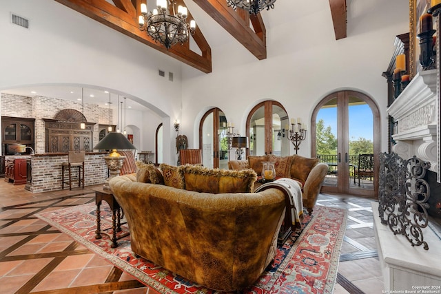 living room with beam ceiling, french doors, a towering ceiling, and an inviting chandelier