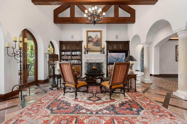 sitting room with beam ceiling, a towering ceiling, an inviting chandelier, and french doors