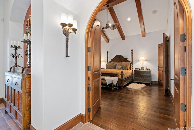 bedroom featuring lofted ceiling with beams, dark wood-type flooring, and a notable chandelier