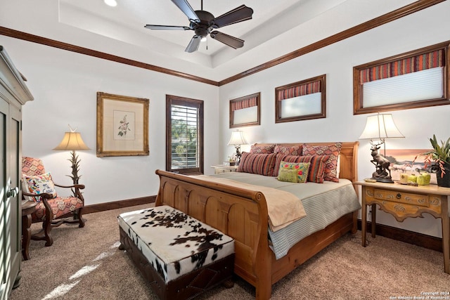 bedroom featuring carpet, a tray ceiling, ceiling fan, and crown molding