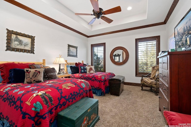 bedroom featuring multiple windows, carpet, a tray ceiling, and ceiling fan