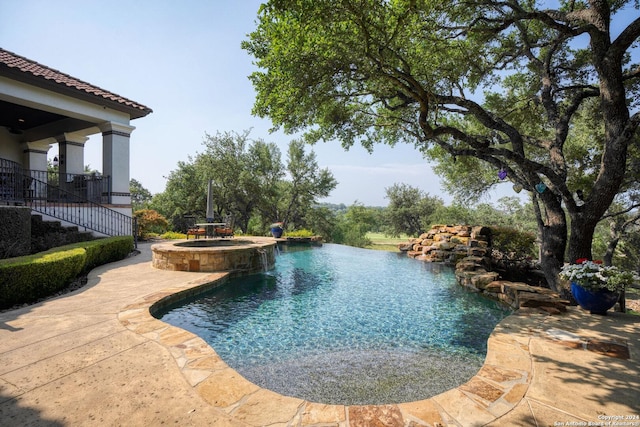 view of pool featuring a patio area and an in ground hot tub