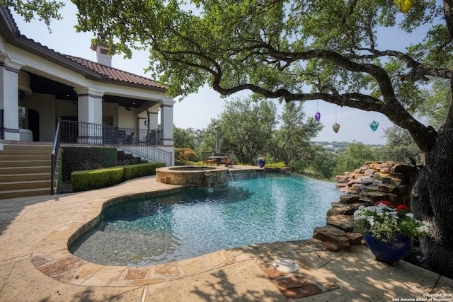 view of swimming pool featuring an in ground hot tub and pool water feature