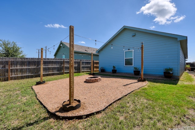 back of house featuring a yard and a fire pit