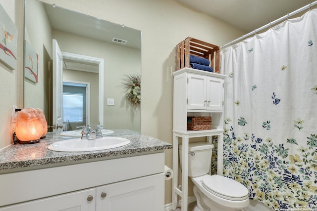 bathroom featuring a shower with curtain, vanity, and toilet