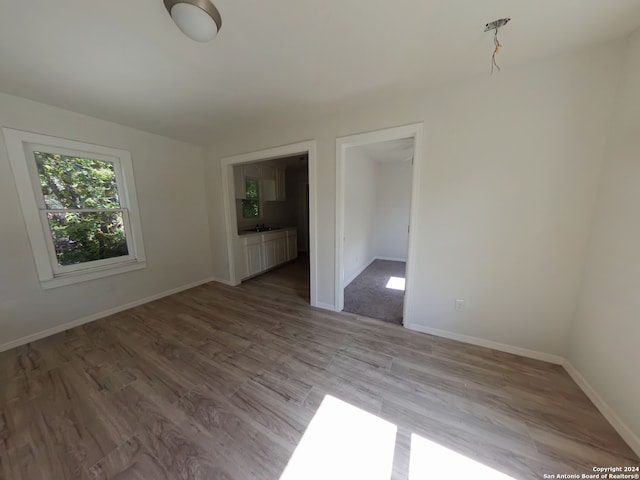 unfurnished room with light hardwood / wood-style flooring and sink