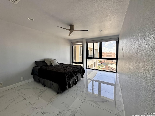 bedroom featuring ceiling fan and a textured ceiling