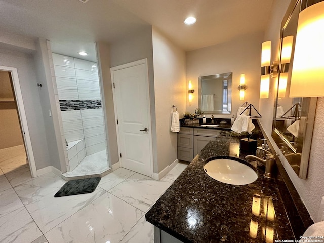 bathroom with tiled shower and vanity