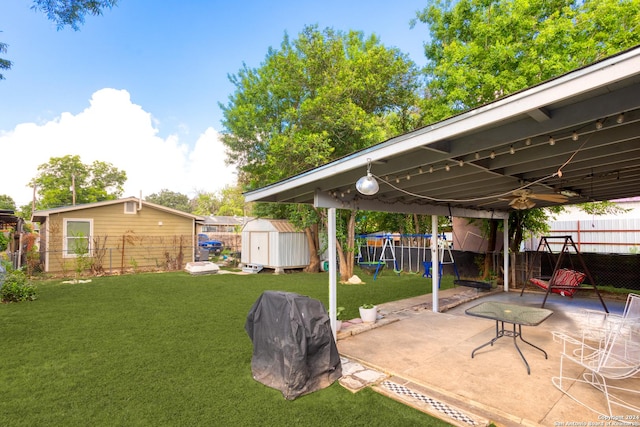 view of yard featuring a shed, a playground, and a patio