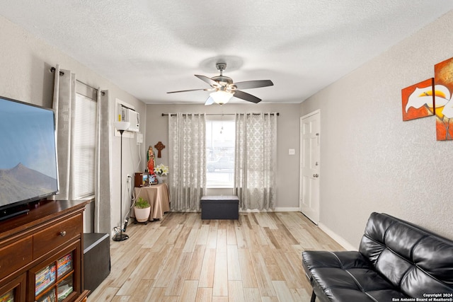 sitting room with a textured ceiling, light hardwood / wood-style flooring, and ceiling fan