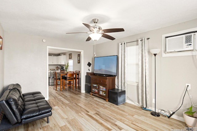 interior space with ceiling fan, light hardwood / wood-style floors, and a wall mounted air conditioner