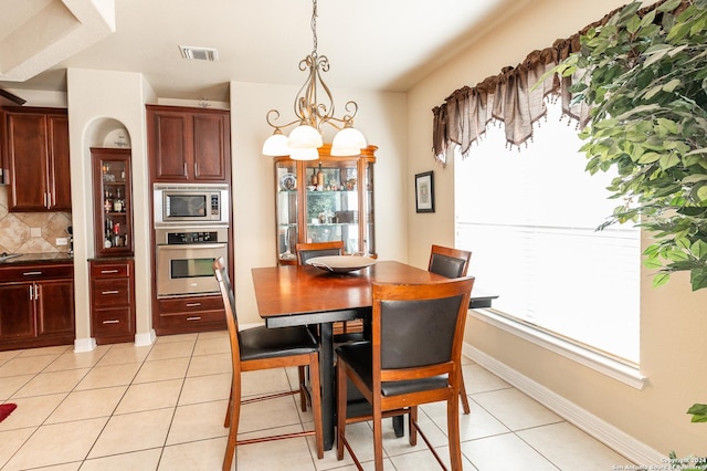 tiled dining area featuring a chandelier