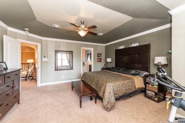 carpeted bedroom featuring ceiling fan, ensuite bathroom, vaulted ceiling, a tray ceiling, and ornamental molding