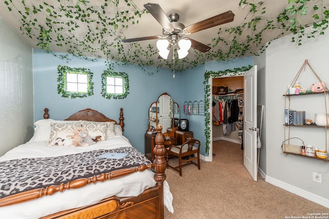 bedroom featuring carpet, ceiling fan, a spacious closet, and a closet