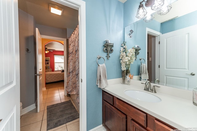 bathroom with tile patterned flooring, vanity, ceiling fan, and toilet