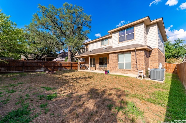 rear view of property featuring a patio, a lawn, and central air condition unit