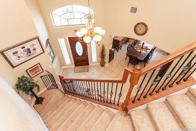 foyer entrance featuring a high ceiling, carpet floors, and an inviting chandelier