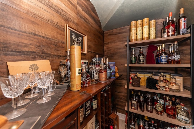 bar with wood walls and lofted ceiling