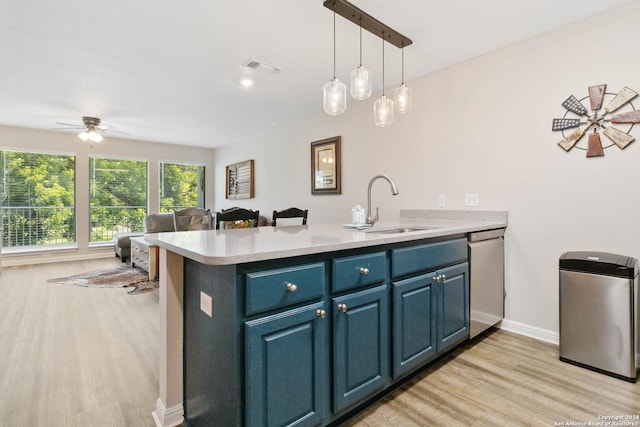 kitchen with blue cabinetry, kitchen peninsula, ceiling fan, and sink