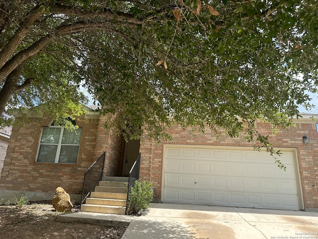 view of property hidden behind natural elements with a garage