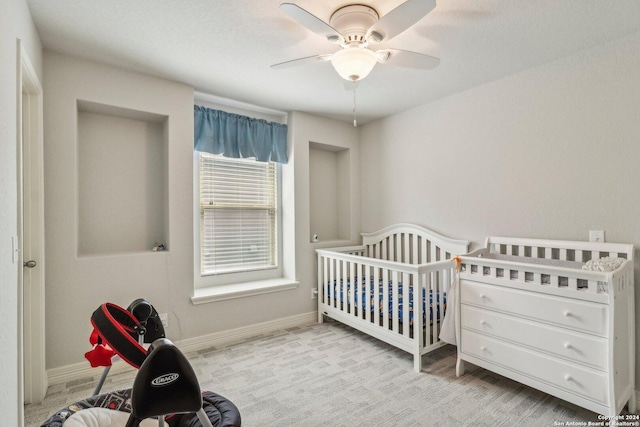 bedroom featuring ceiling fan and a crib