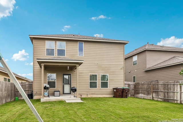 rear view of house featuring a patio area and a lawn