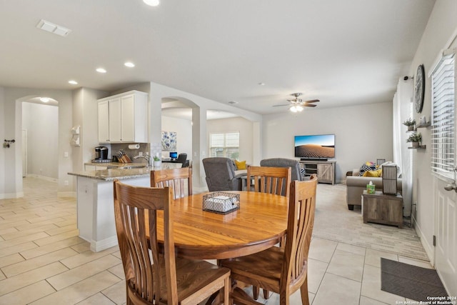 dining space with ceiling fan and sink