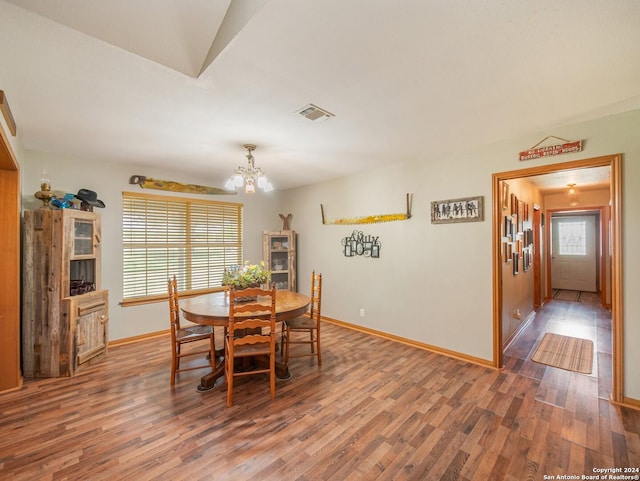 dining room featuring dark hardwood / wood-style flooring and an inviting chandelier