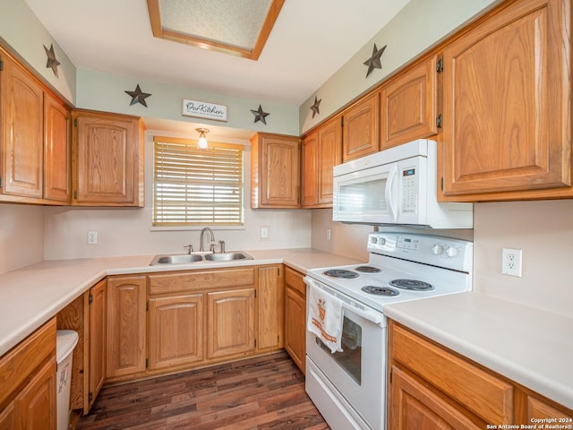 kitchen featuring sink, dark wood-type flooring, and white appliances