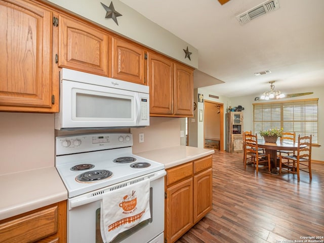 kitchen featuring dark hardwood / wood-style flooring, white appliances, and an inviting chandelier