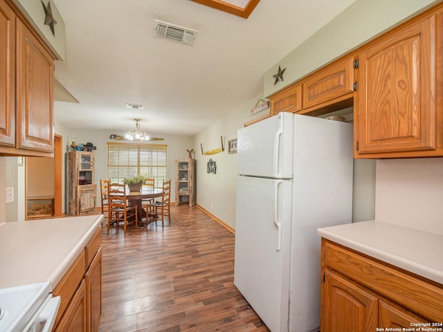 kitchen featuring dark hardwood / wood-style floors, white fridge, stove, and an inviting chandelier