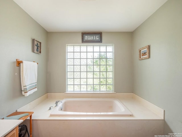 bathroom featuring a washtub and vanity