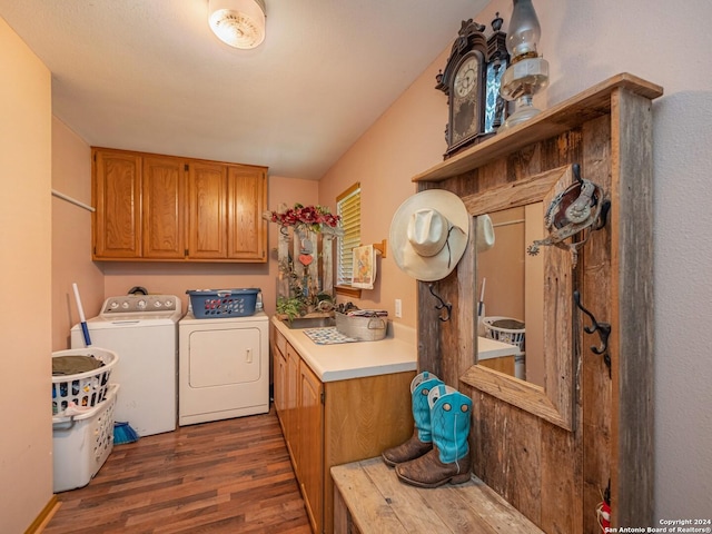 laundry room featuring washer and dryer, cabinets, and dark wood-type flooring