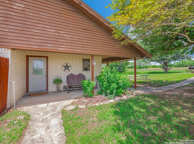 view of exterior entry with a lawn