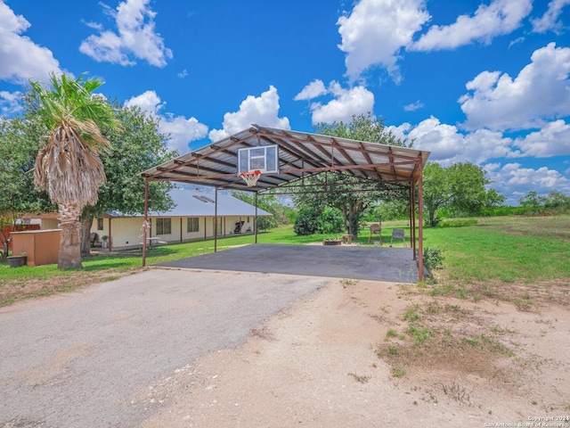 view of parking featuring a lawn and a carport